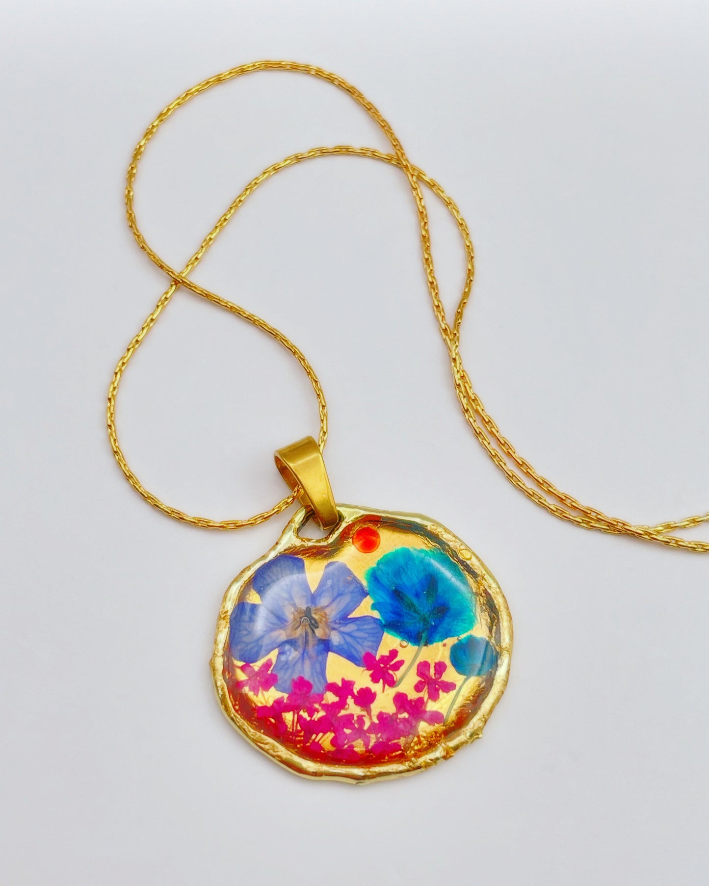 Gold pendant necklace with pink and blue flowers
