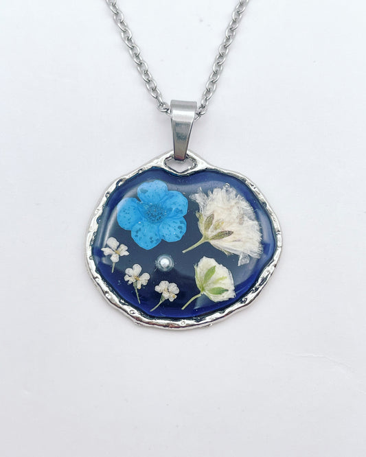 Black pendant necklace with blue and white flowers