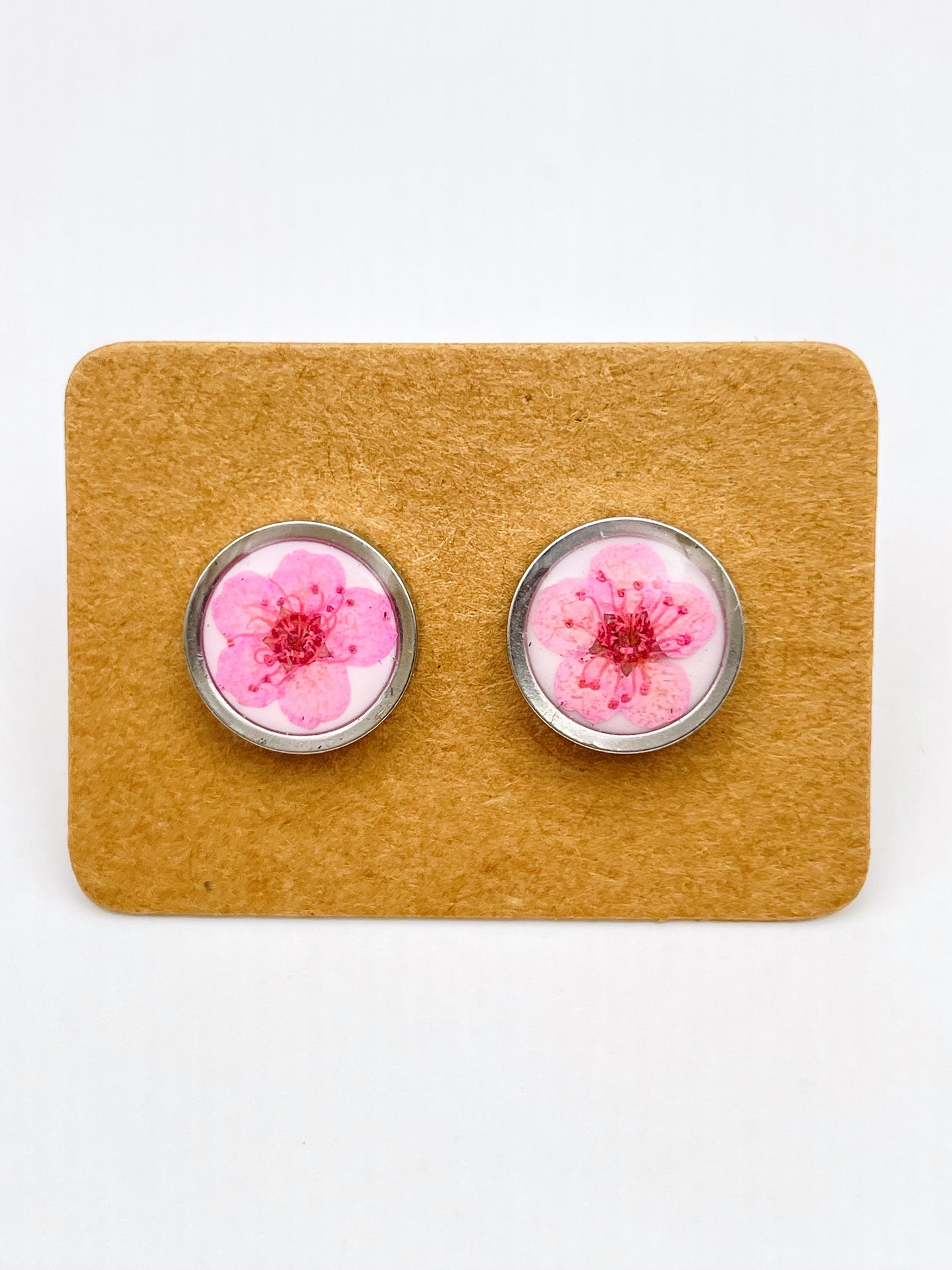 Stud earrings with pink flowers in white lacquer