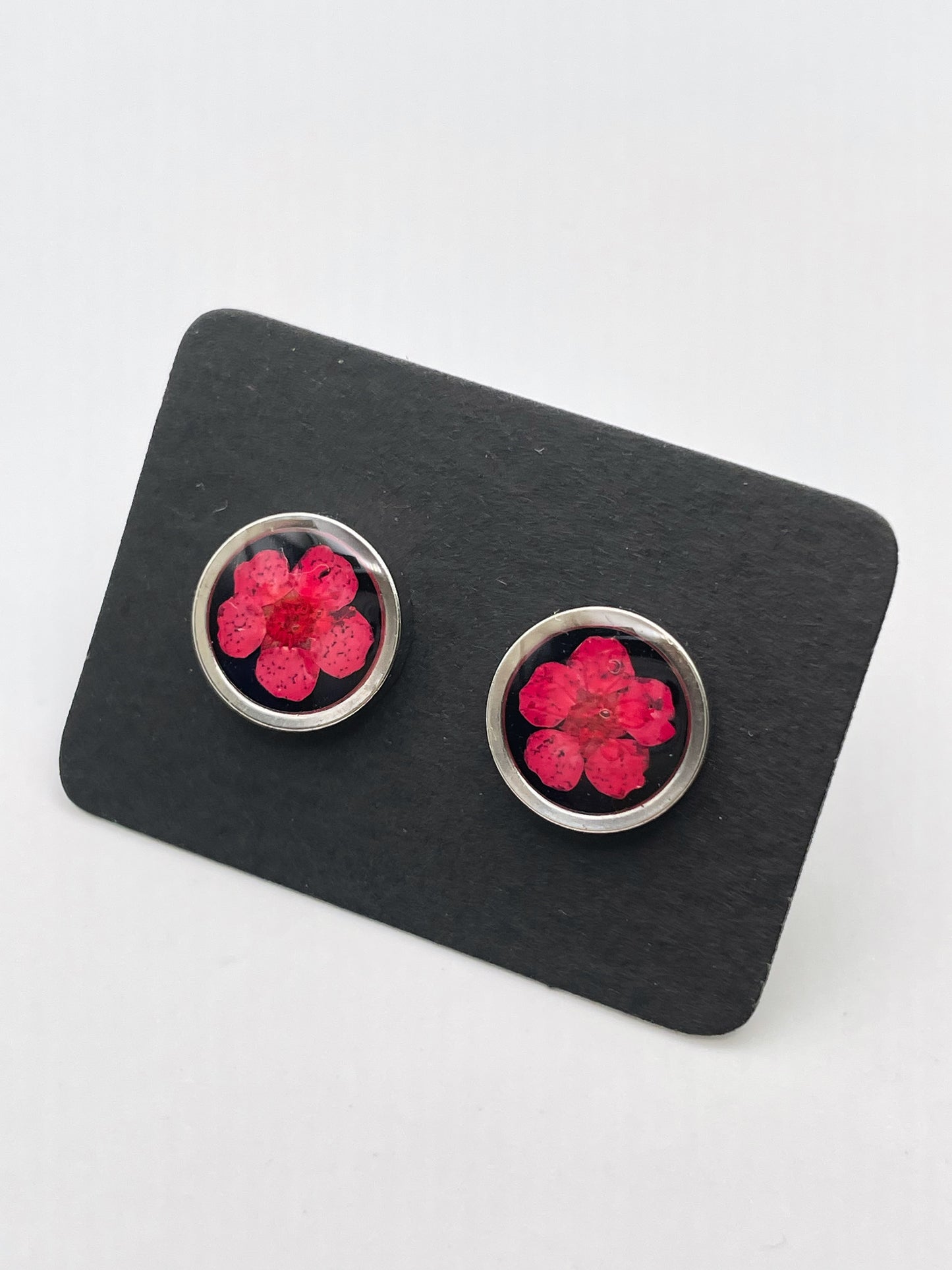 Stud earrings with red flowers in black lacquer