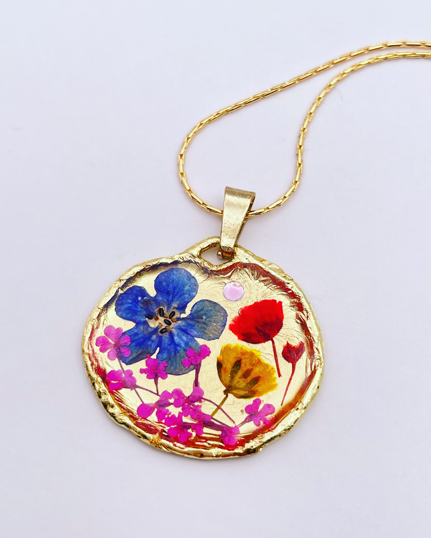 Gold pendant necklace with red and blue flowers