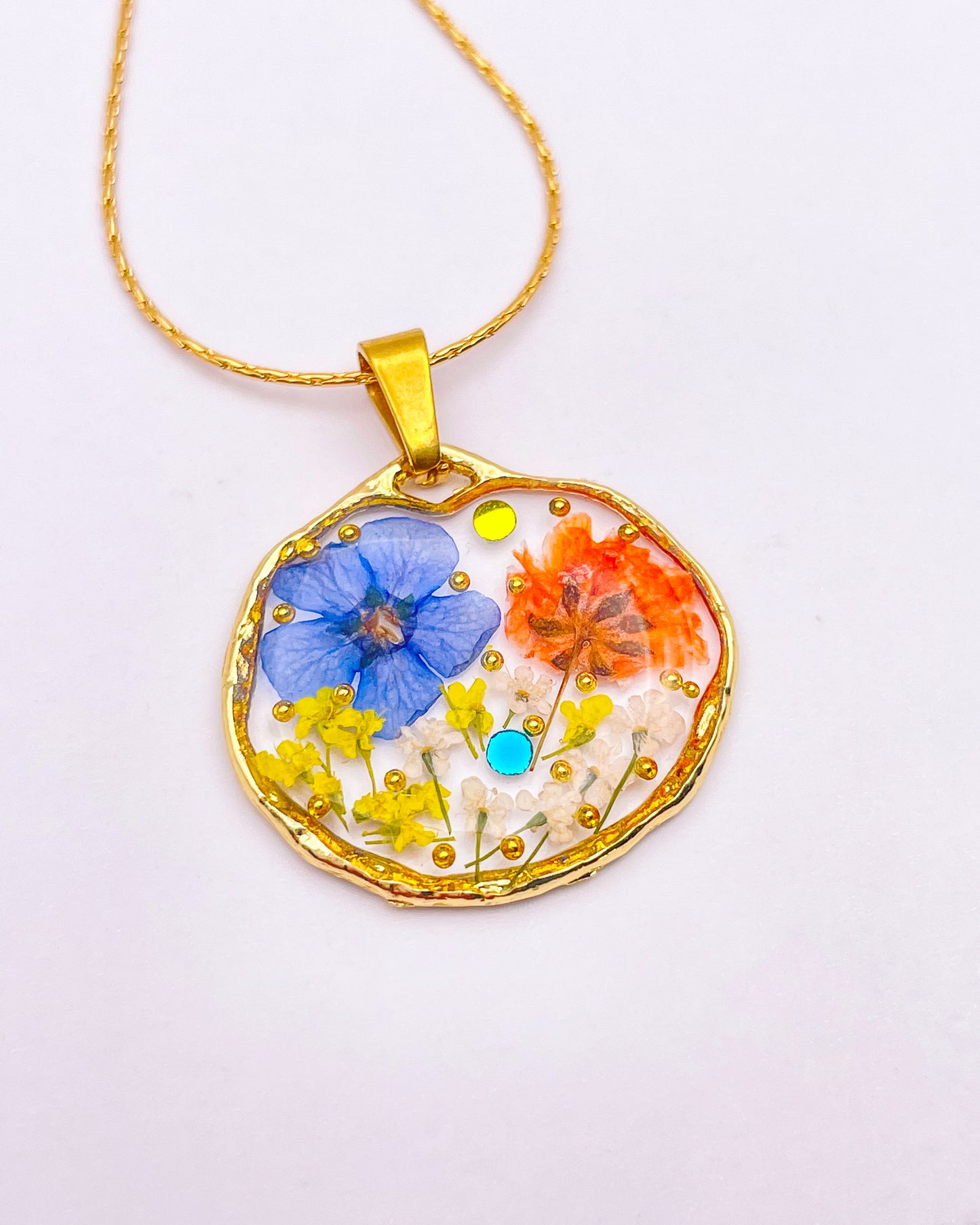 Pendant necklace with orange and blue flowers