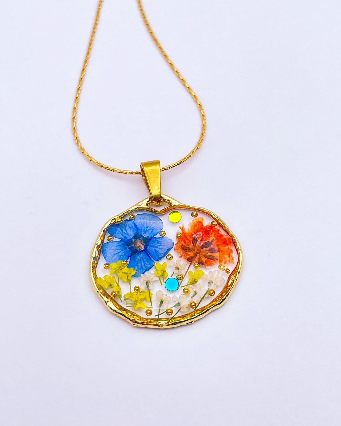 Pendant necklace with orange and blue flowers