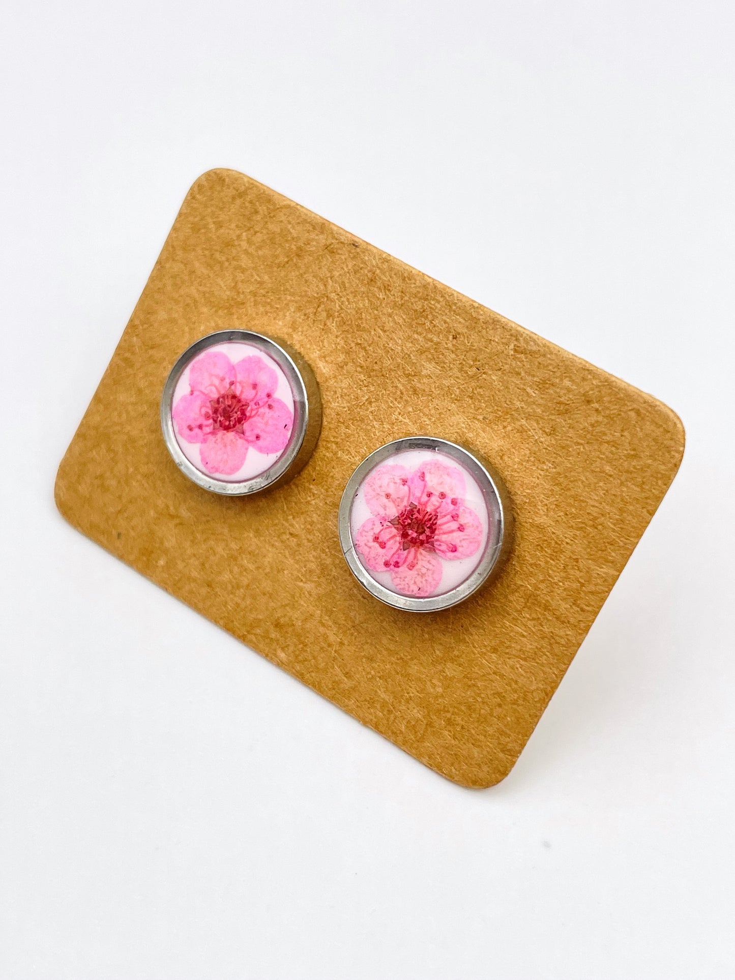 Stud earrings with pink flowers in white lacquer