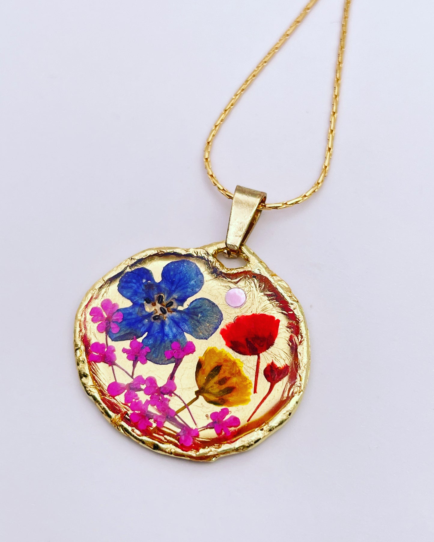 Gold pendant necklace with red and blue flowers