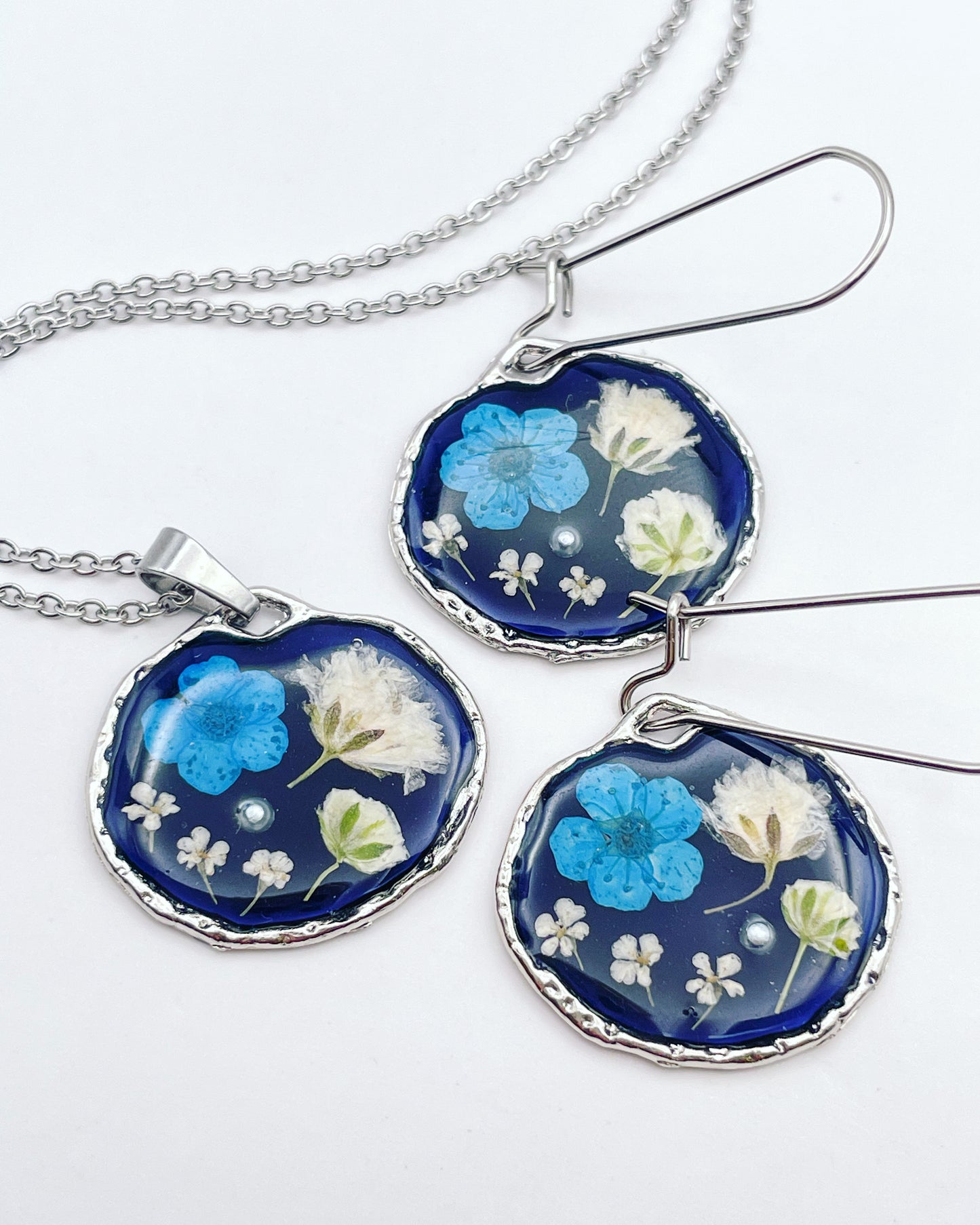 Boucles d'oreilles pendantes noires avec fleurs bleues et blanches