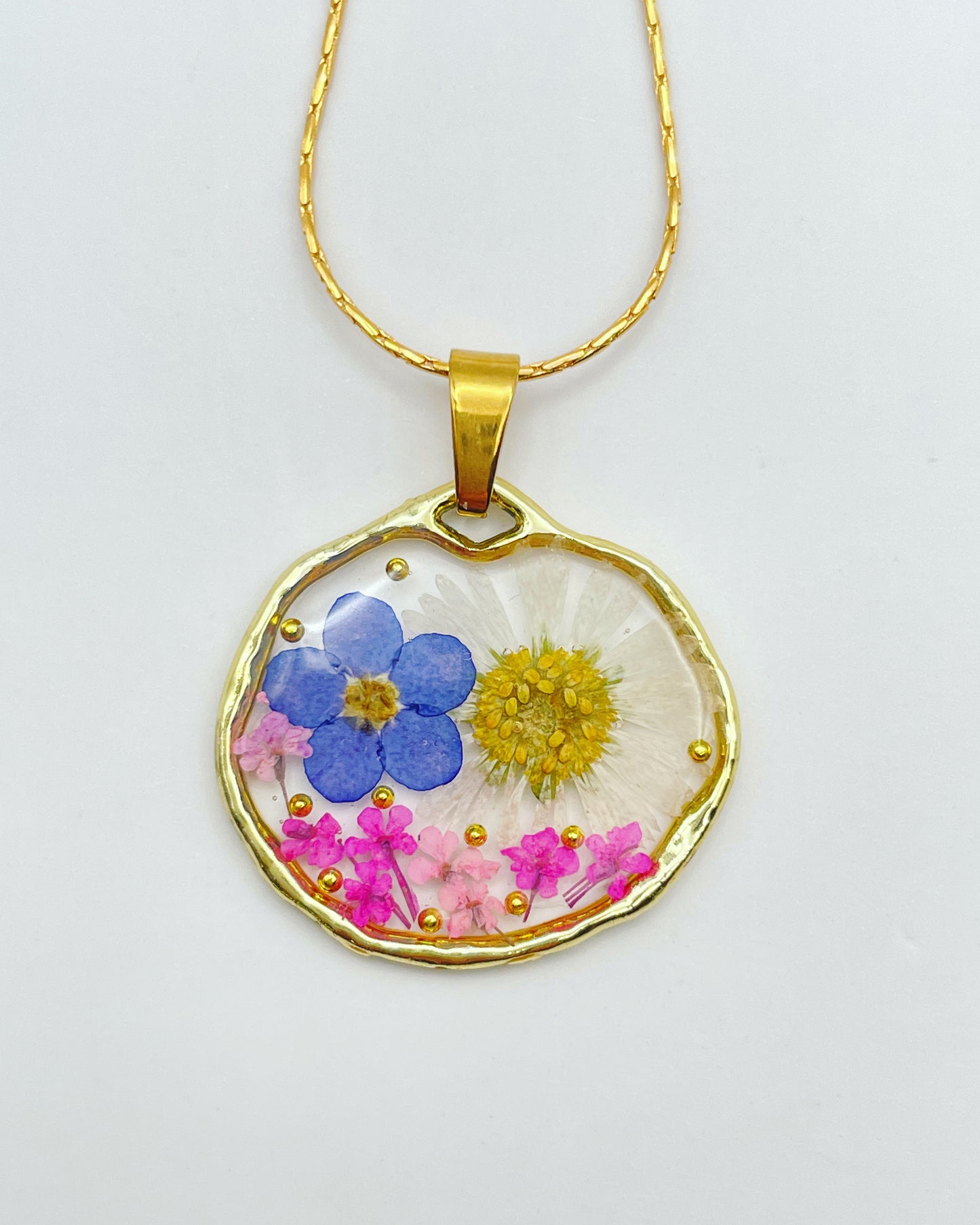 Pendant necklace with daisy and forget me not flowers