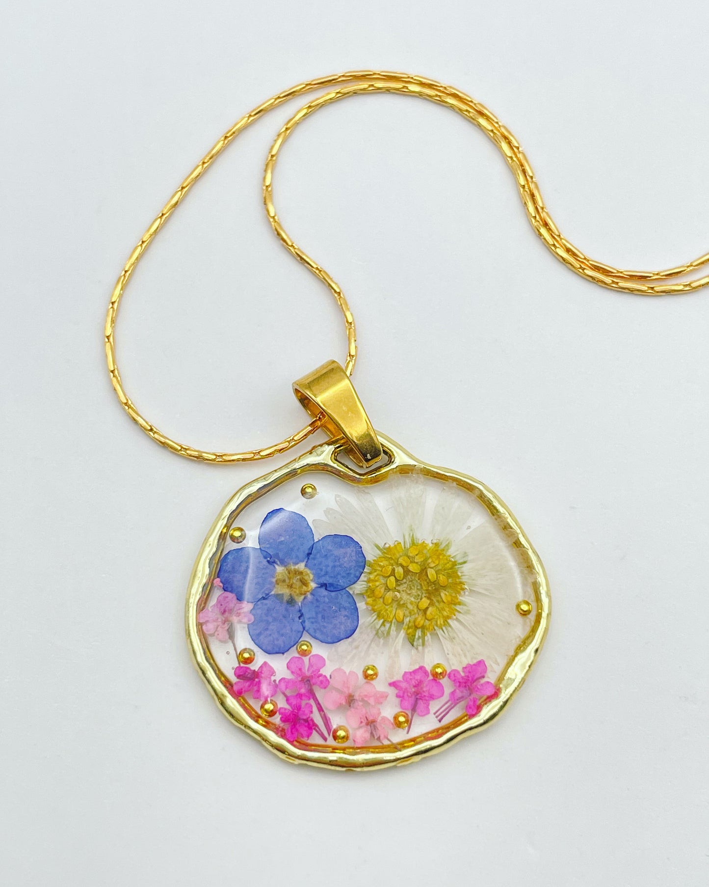 Pendant necklace with daisy and forget me not flowers