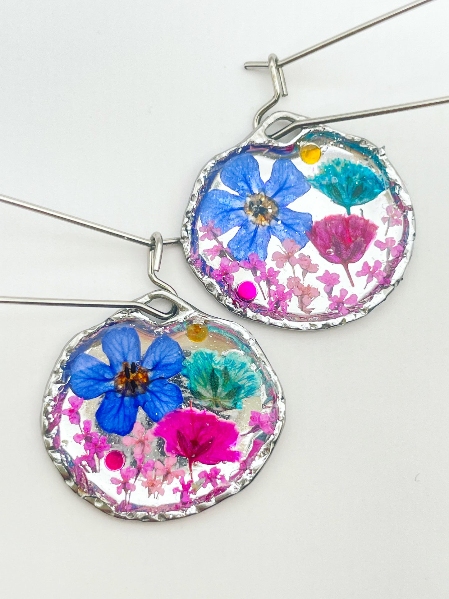 Goldene Hängeohrringe mit rosa und blauen Blumen