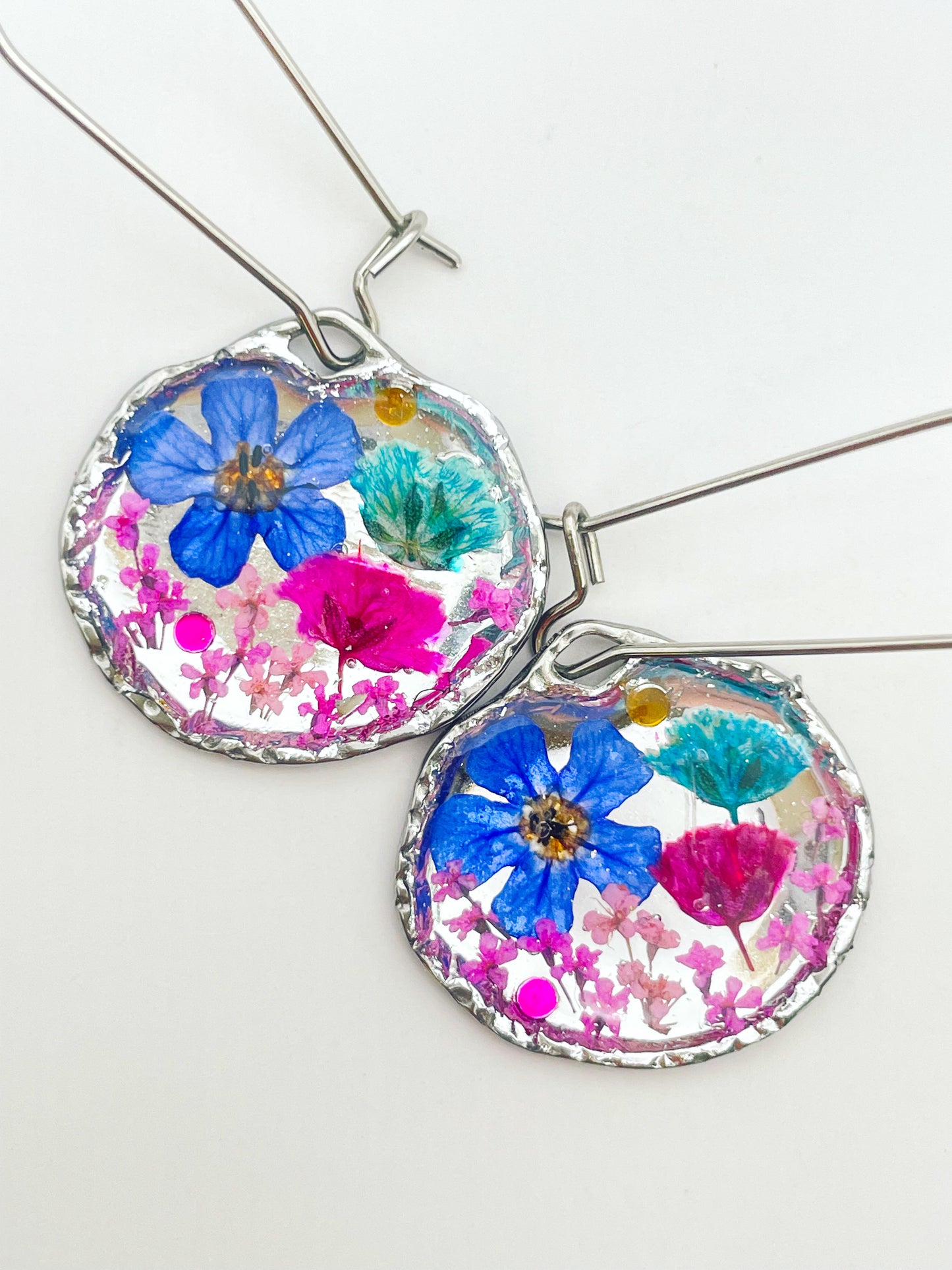 Goldene Hängeohrringe mit rosa und blauen Blumen
