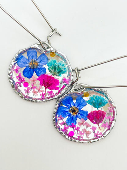 Goldene Hängeohrringe mit rosa und blauen Blumen