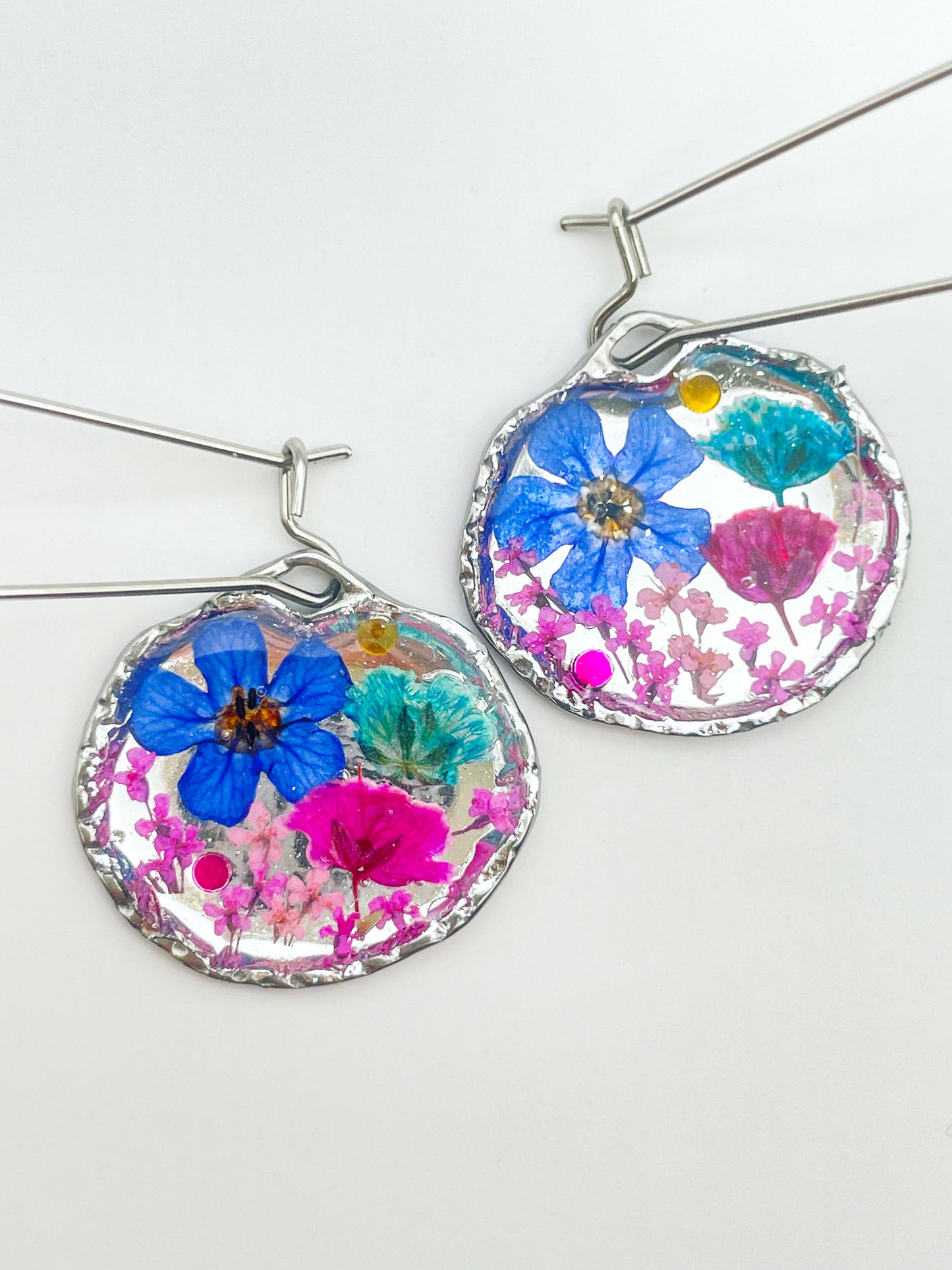 Goldene Hängeohrringe mit rosa und blauen Blumen