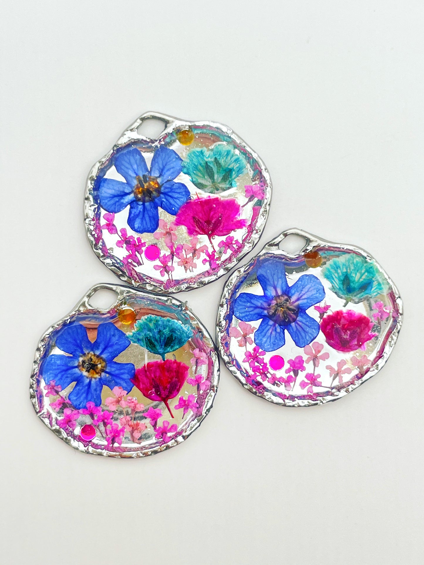Goldene Hängeohrringe mit rosa und blauen Blumen