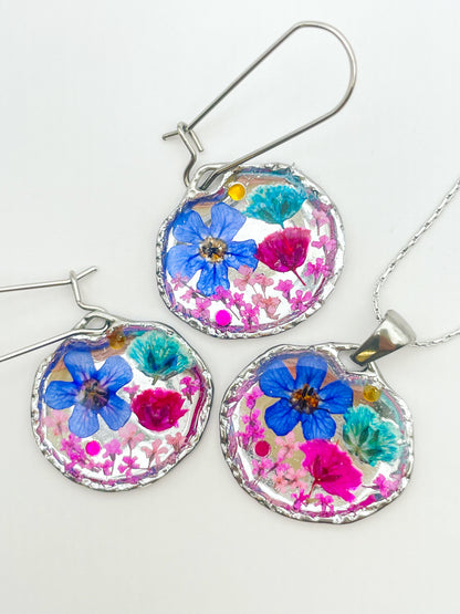 Goldene Hängeohrringe mit rosa und blauen Blumen